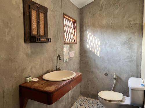 a bathroom with a sink and a toilet at Baan rabiang Pai บ้านระเบียงปาย in Pai