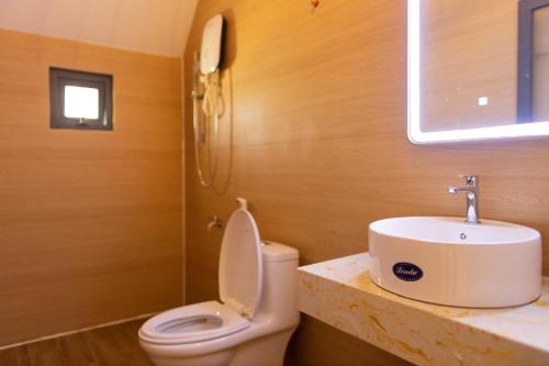 a bathroom with a toilet and a sink at The Homilá Bảo Lộc - Hill View Bungalow & Glamping in Bao Loc