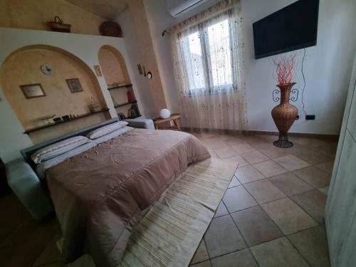 a bedroom with a bed and a television in it at Casa Oliena in Oliena