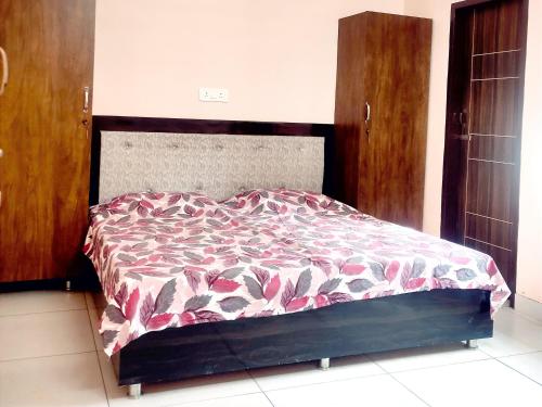 a bedroom with a bed with a red and white comforter at SHUBHAM VILLA -- Super Deluxe Rooms -- LPU Law Gate in Phagwāra