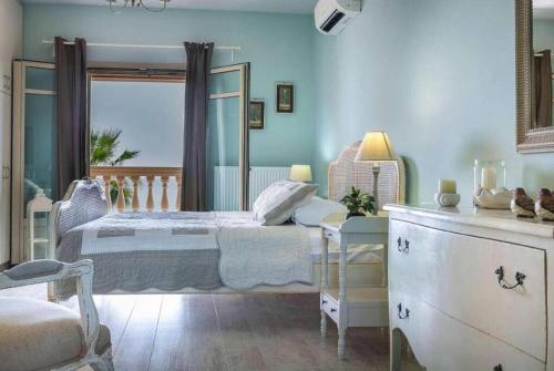 Dormitorio azul con cama y ventana en Villa Alegria Kefalonia en Argostoli