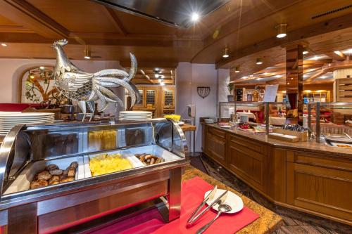 a restaurant with a buffet with a chicken on it at IFA Alpenhof Wildental Hotel Kleinwalsertal Adults only in Mittelberg