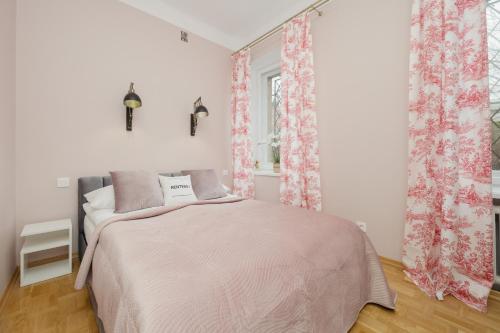 a bedroom with a bed with pink curtains and a window at Royal Castle View Warsaw by Renters in Warszawa