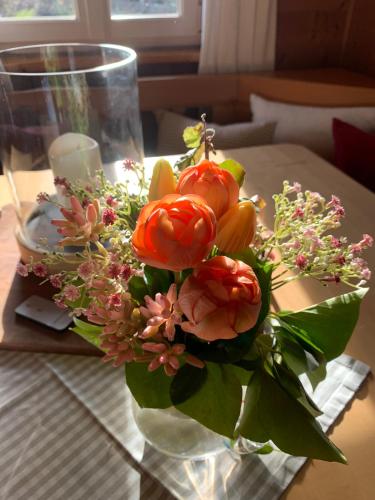 a vase filled with flowers on a table at Ferien Haus am Feldgarten mit 160 qm für 2 bis 9 Personen in Raubling