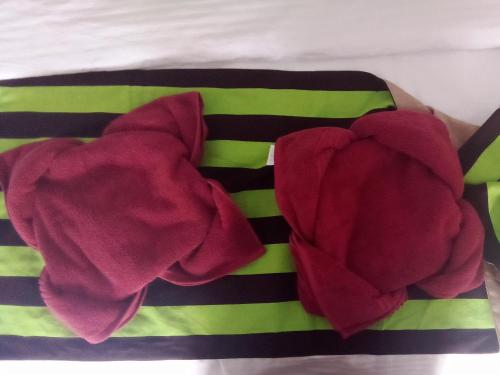 a pile of red towels sitting on top of a bed at Forest Rawana homestay Ella in Ella
