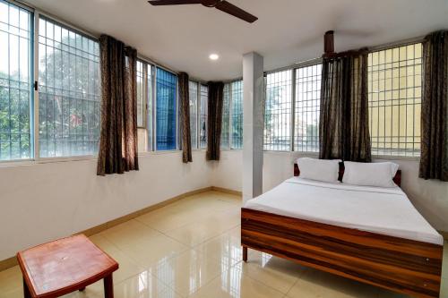 Schlafzimmer mit einem Bett, einem Stuhl und Fenstern in der Unterkunft OYO Hotel Lake View in Ranchi