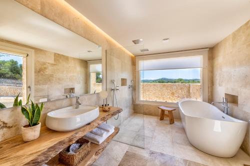 a bathroom with a large tub and a large window at Es Lligats Agroturismo - Adults Only in Sant Llorenç des Cardassar