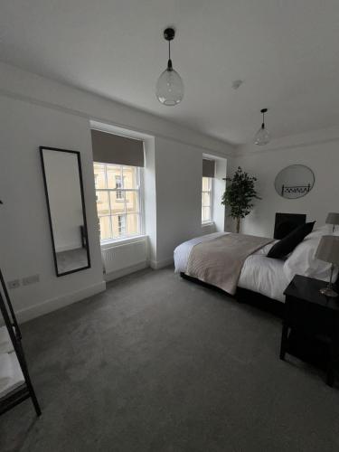 - une chambre avec un grand lit et un miroir dans l'établissement 2 Kingsmead Square, à Bath