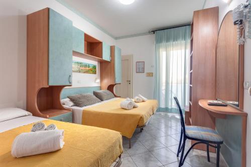 une chambre d'hôtel avec deux lits et un canapé dans l'établissement Hotel Atlantic, à Gatteo a Mare