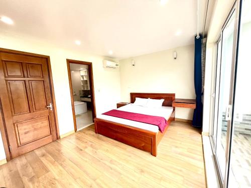 1 dormitorio con 1 cama y puerta de madera en Homestay yên bình tại Ecopark, en Cong Luận