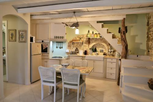 una cocina con mesa y sillas y una escalera en Petite Olive House, en Sitia