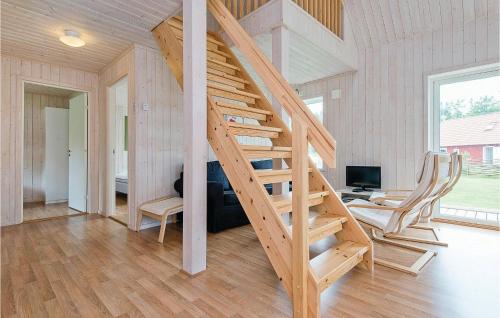 a wooden staircase in a home with a desk and chairs at Stunning Home In Holmsjö With Kitchen in Holmsjö