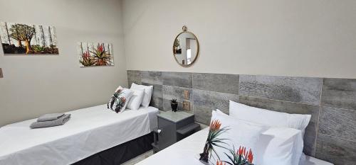 a room with two beds and a mirror at Grazia Overnight accommodation in Harrismith