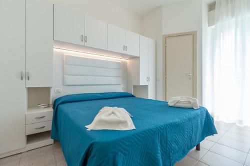 a bedroom with a blue bed with white cabinets at Hotel La Plage in Cattolica