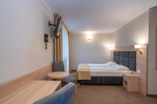 a hotel room with a bed and a table and chairs at Pensjonat Carmen in Szklarska Poręba