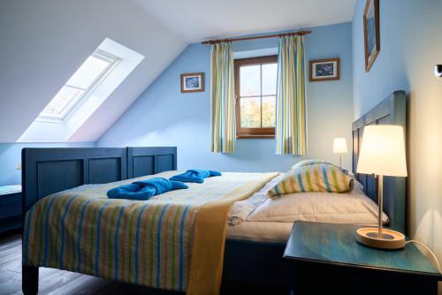 a blue bedroom with a bed and a table at Penzion Kvítko in Vacov