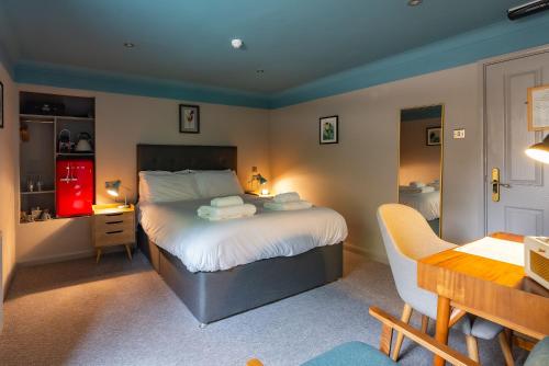 a bedroom with a bed with a desk and a desk at The Georgian Townhouse in Norwich