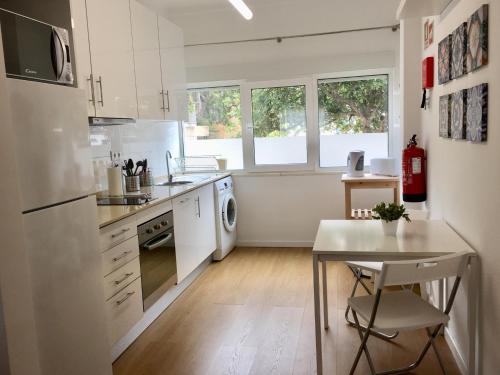 a kitchen with white appliances and a table in it at Feel Cascais Center 2bd in Cascais
