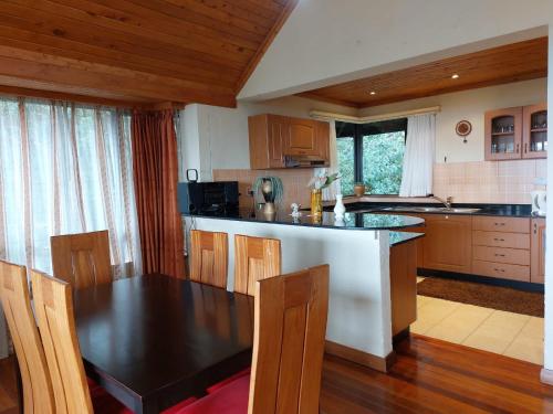une cuisine avec une table noire et des placards en bois dans l'établissement Great Rift Valley Lodge and Golf Resort, à Naivasha