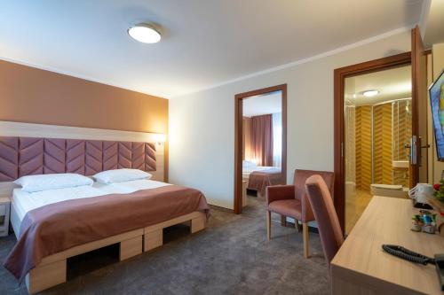 a hotel room with a large bed and a desk at Pensjonat Carmen in Szklarska Poręba