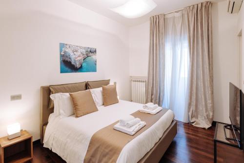 Piccinni Exclusive Suite في باري: غرفة نوم عليها سرير وفوط
