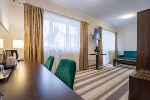 a conference room with a long table and green chairs at Pensjonat Carmen in Szklarska Poręba