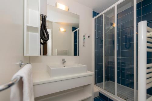 y baño con lavabo y ducha. en Residence Vacances Bleues Lou Castel, en Casteljau