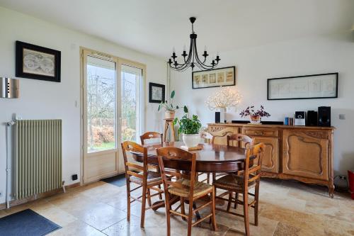 une salle à manger avec une table et des chaises dans l'établissement Maison Boisée - Charmante maison au calme, à Courbépine