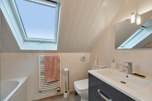 baño con lavabo y aseo y ventana en Maison Boisée - Charmante maison au calme 