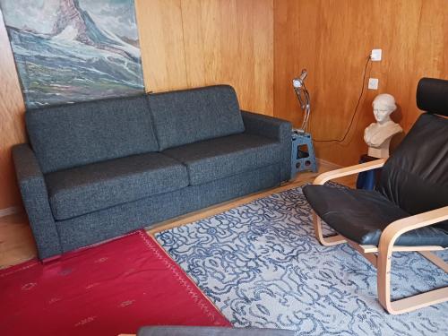 een woonkamer met een bank en 2 stoelen bij Chalet Hirsch in Grächen