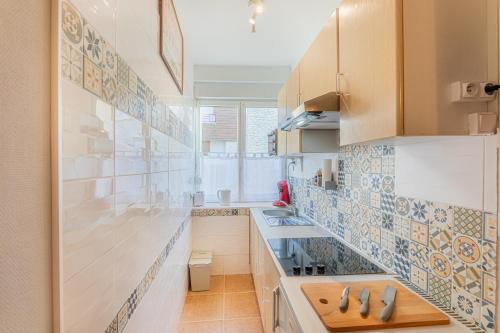 - une cuisine avec du carrelage bleu et blanc sur le mur dans l'établissement Le Chardonnay - Studio à Lussault-sur-Loire, à Lussault-sur-Loire