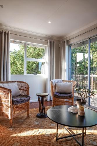 a living room with two chairs and a table at Soutelande Country Stay - Close to 1#Beach in PE in Port Elizabeth