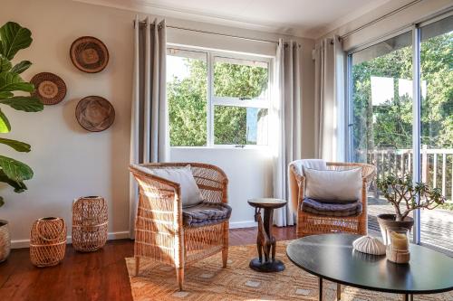a living room with wicker chairs and a table at Soutelande Eco-Hideaway - 2min Drive to Pristine Beach in Port Elizabeth