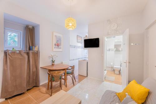 un salon avec une table et une salle de bains. dans l'établissement Le Chardonnay - Studio à Lussault-sur-Loire, à Lussault-sur-Loire