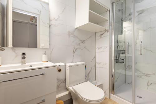 une salle de bain blanche avec toilettes et douche dans l'établissement Cap City - Studio climatisé à Agde, au Cap d'Agde