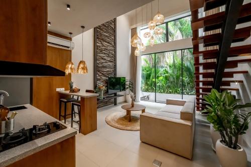 an open kitchen and living room with a large window at Sunny Cuddles in Canggu