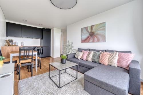 sala de estar y cocina con sofá y mesa en Cozy Apartment with panoramic view, en Anykščiai
