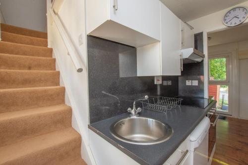 a kitchen with a sink and a staircase at Chalet 137 in Deal