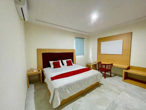 MandaiにあるRedDoorz @ Wisma Graha Andi Djemmaのベッドルーム1室(ベッド1台、テーブル、椅子付)