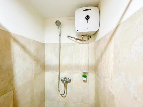 a shower in a bathroom with a shower head at RedDoorz @ Wisma Graha Andi Djemma in Manda