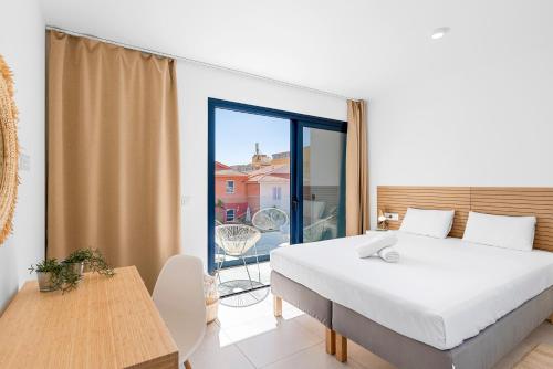 a bedroom with a large bed and a balcony at MEDANO4YOU Arecas Del Mar in El Médano