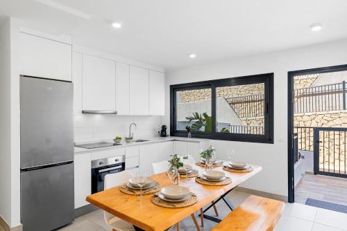 a kitchen with a wooden table and a dining room at MEDANO4YOU Arecas Del Mar in El Médano