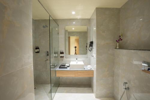 a bathroom with a sink and a glass shower at Regenta Central Puri Odisha in Puri