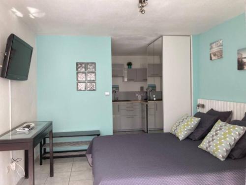 Cette chambre comprend un lit, une table et une cuisine. dans l'établissement Studio 513, Port Soleil B3 au village naturiste, au Cap d'Agde
