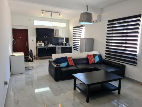 uma sala de estar com um sofá preto e uma mesa em Lovely 1-Bed Apartment in Luanda em Luanda