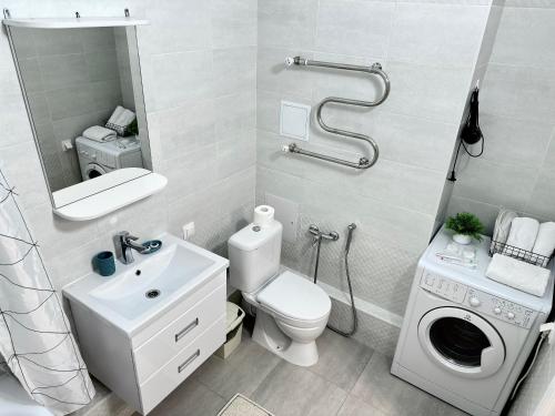 bagno con servizi igienici, lavandino e specchio di Only Sun a Astana