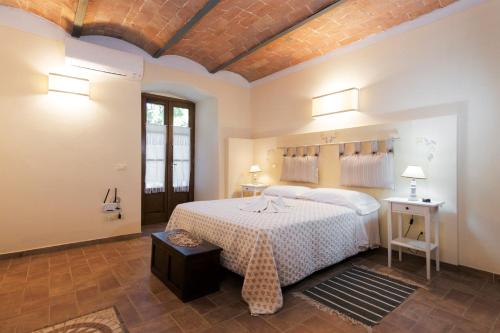 ein Schlafzimmer mit einem großen weißen Bett in einem Zimmer in der Unterkunft Agriturismo La Quiete in Volterra