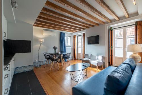 ein Wohnzimmer mit einem blauen Sofa und einem Tisch in der Unterkunft Living Lisboa Baixa Apartments in Lissabon