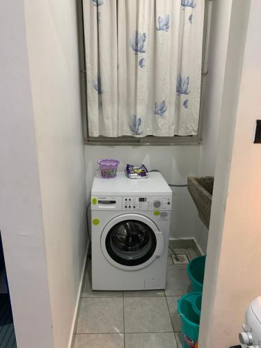 a washing machine in a bathroom with a window at Greenzone Apartments in Kiambu