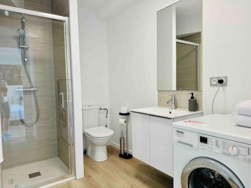 W łazience znajduje się toaleta, prysznic i pralka. w obiekcie Charmant T2 * proche plage * parking gratuit w La Rochelle